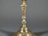 pair of antique brass candlesticks on a grey background