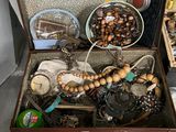 une valise remplie de bijoux et d'autres objets posée sur une table