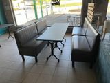 tables and benches in a restaurant with a view of the street