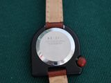 a close up of a watch on a green surface