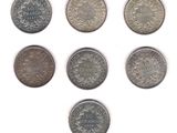 a group of six different coins sitting on top of a white surface