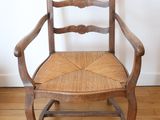 a wooden chair with a woven seat on a hard wood floor