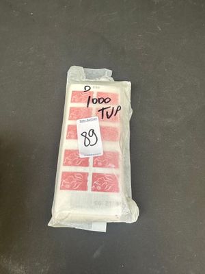 un sac de provisions posé par terre à côté d'une bouteille de soda