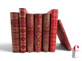 several red books are stacked on top of each other on a white surface