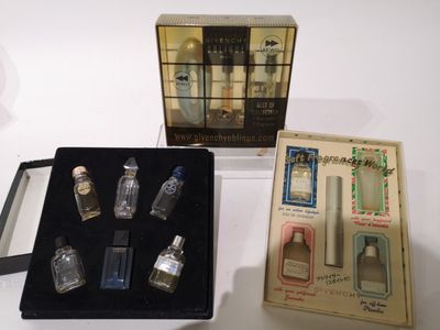 une boîte de parfums posée sur une table à côté d'une autre boîte de parfums