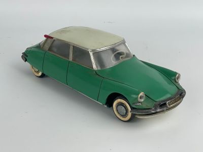 a green toy car that is sitting on a white surface