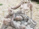 une statue de femme assise au sommet d'un rocher