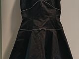 a black dress hanging on a hanger in a room