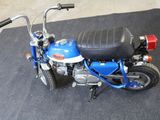 a small blue motorcycle with a black seat on the floor