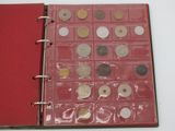 a red book with a bunch of coins inside of it