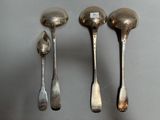 three silver spoons and two silver spoons on a table