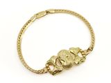 gros plan d'un bracelet en or sur fond blanc