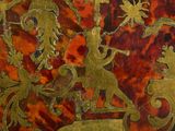 a close up of a gold and red painting on a wall