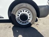 a white truck with a flat tire parked in a parking lot