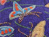 purple beaded purse with colorful butterflies and flowers on it