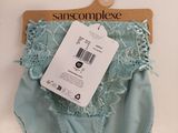 a blue panties with a tag on it on a wooden hanger