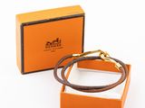 une boîte orange contenant un bracelet en cuir marron