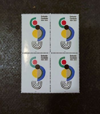 four postage stamps with different designs on them sitting on a table