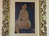 painting of a nude woman in a gold frame on a wall