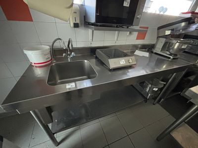 une cuisine équipée d'un évier et d'un micro-ondes