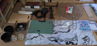 une table sur laquelle se trouvent de nombreux objets et un ordinateur portable