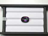 une pierre en verre noire et violette dans un coffret noir