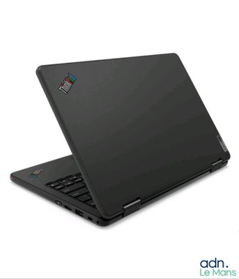L'ordinateur portable noir est ouvert sur une surface blanche ; un autocollant bleu et vert est collé sur l'écran.