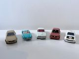 plusieurs petites voitures sont alignées sur une surface blanche