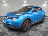Une Nissan Juke bleue est garée dans une pièce dont le sol est en damier.