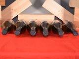 several bottles of wine are lined up on a red table cloth