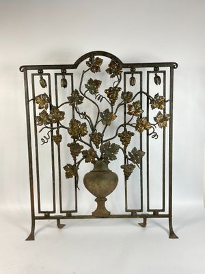 an image of a metal screen with a vase and leaves on it