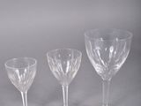 three clear wine glasses sitting on top of a white table