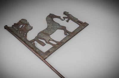une vieille enseigne en métal représentant un cheval et son cavalier