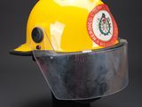 yellow hard hat with clear visor on a black base