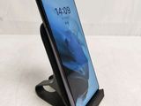 a close up of a phone on a stand on a white surface