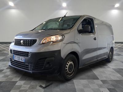 la camionnette argentée est garée sur un sol en damier dans le garage