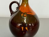 a brown vase with a man on it on a table