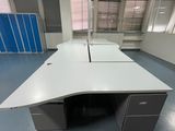 un bureau dans une pièce équipée d'armoires bleues et d'un bureau blanc