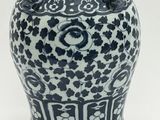 un vase bleu et blanc posé sur une surface blanche