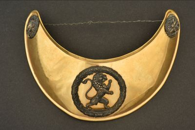 plaque en laiton sur laquelle est représenté un lion et un serpent