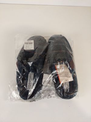 deux paires de chaussures noires sont emballées dans du plastique sur une surface blanche
