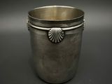 une coupe ancienne en argent avec une anse en forme de coquillage, sur fond noir
