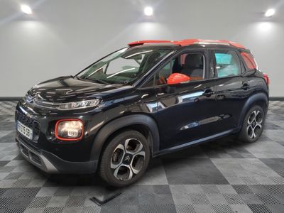 Une Citrole noire et rouge est garée sur un sol à damier