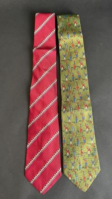 two neck ties with different designs on them sitting on a table