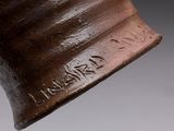 a close up of a brown vase with writing on it