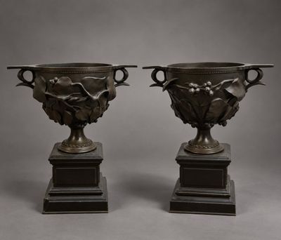une paire de vases en bronze sur socles, sur fond gris