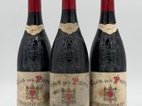 three bottles of wine are lined up on a white surface