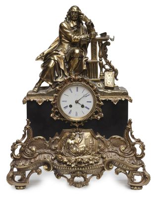 a gold clock with a statue on top of it