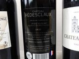 three bottles of red wine sitting on a table