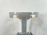a close up of a pair of earrings on a stand